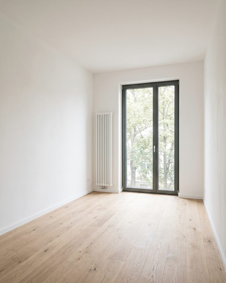 Leerer, frisch sanierter Wohnraum mit Eichendielen und großem Fenster